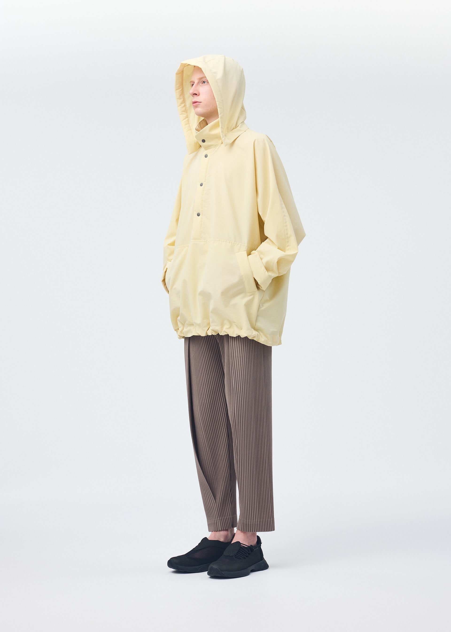 A model wears the HOMME PLISSÉ ISSEY MIYAKE PADDED RIM SHIRT shirt.