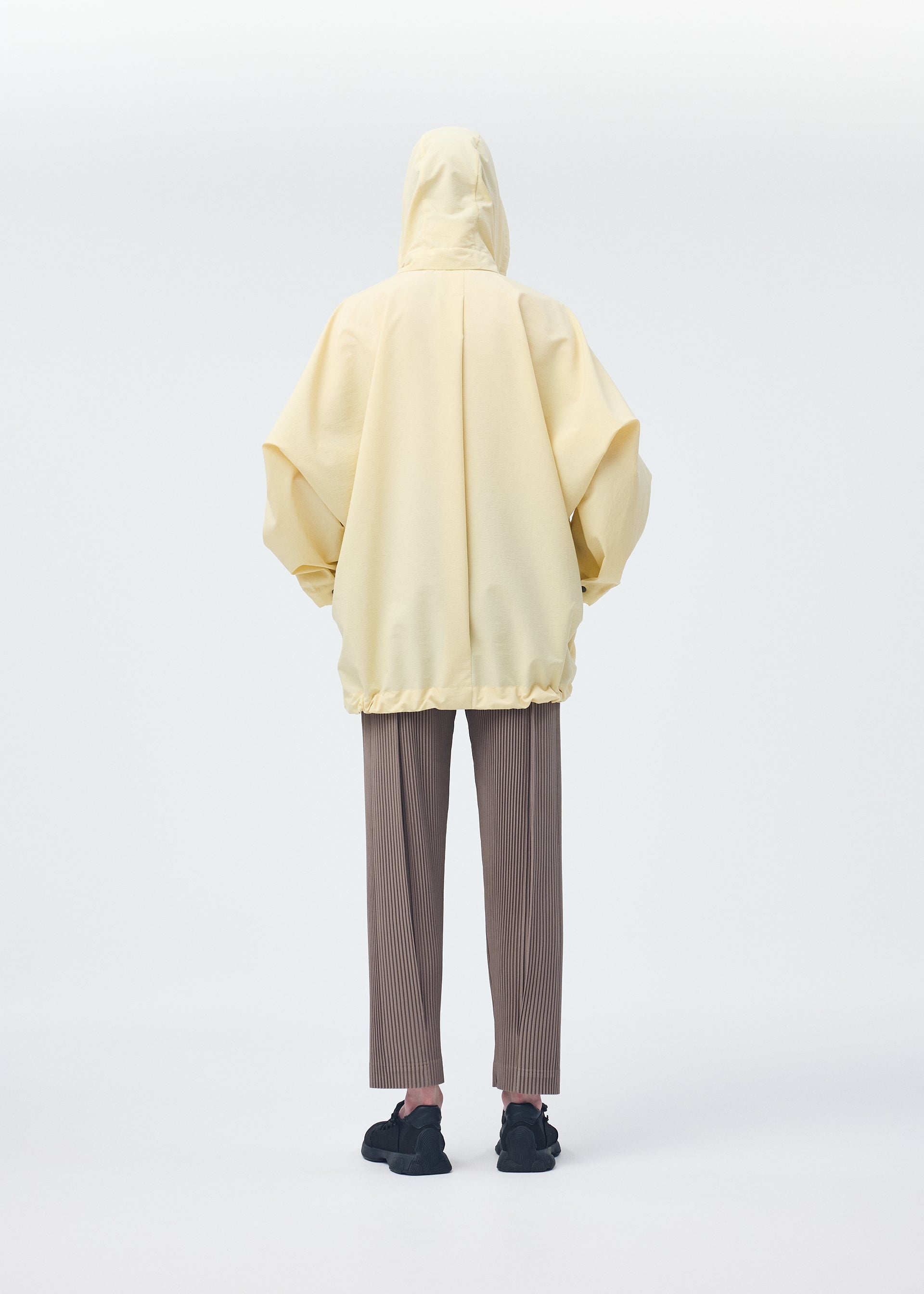 A model wears the HOMME PLISSÉ ISSEY MIYAKE PADDED RIM SHIRT shirt.