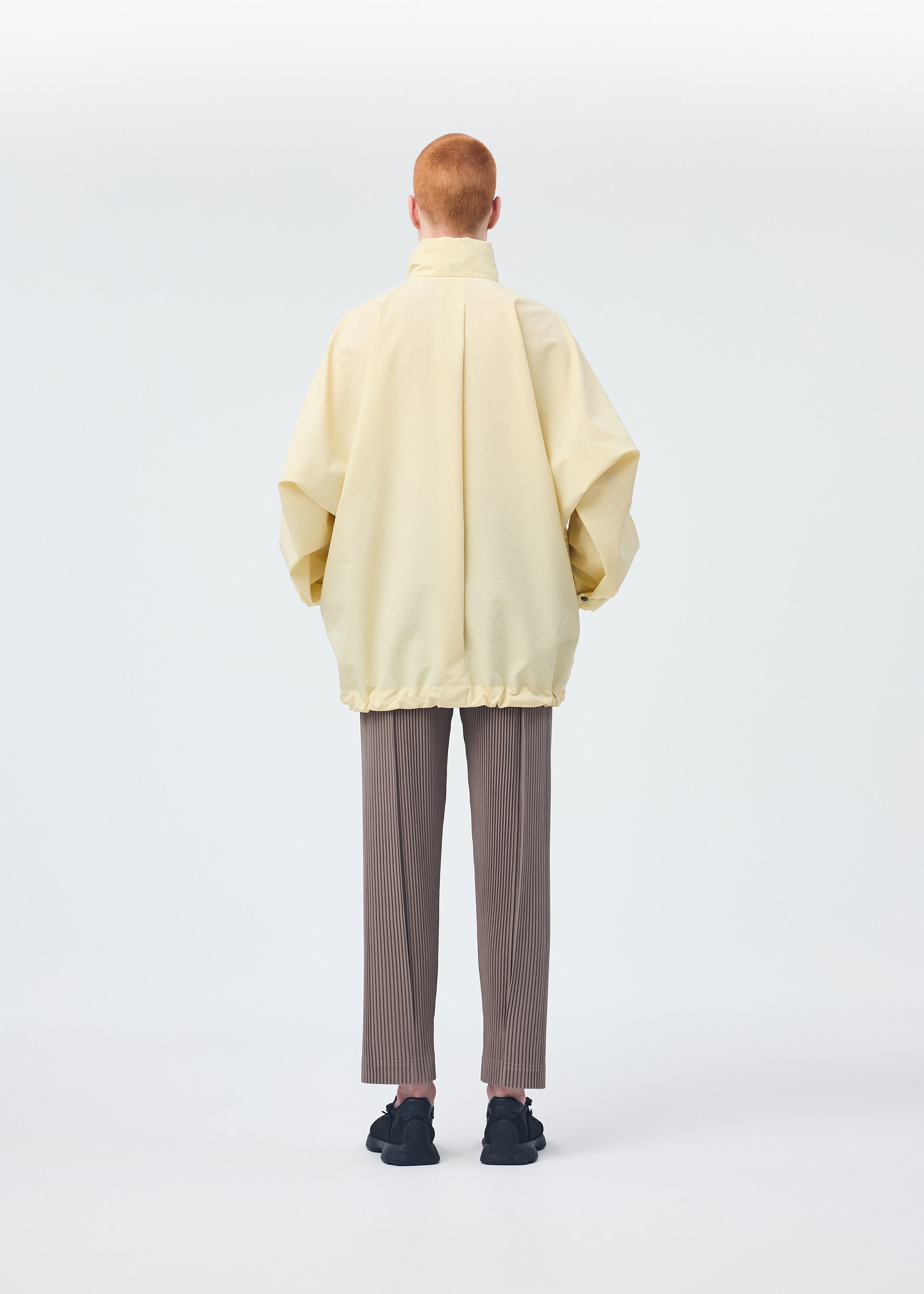 A model wears the HOMME PLISSÉ ISSEY MIYAKE PADDED RIM SHIRT shirt.
