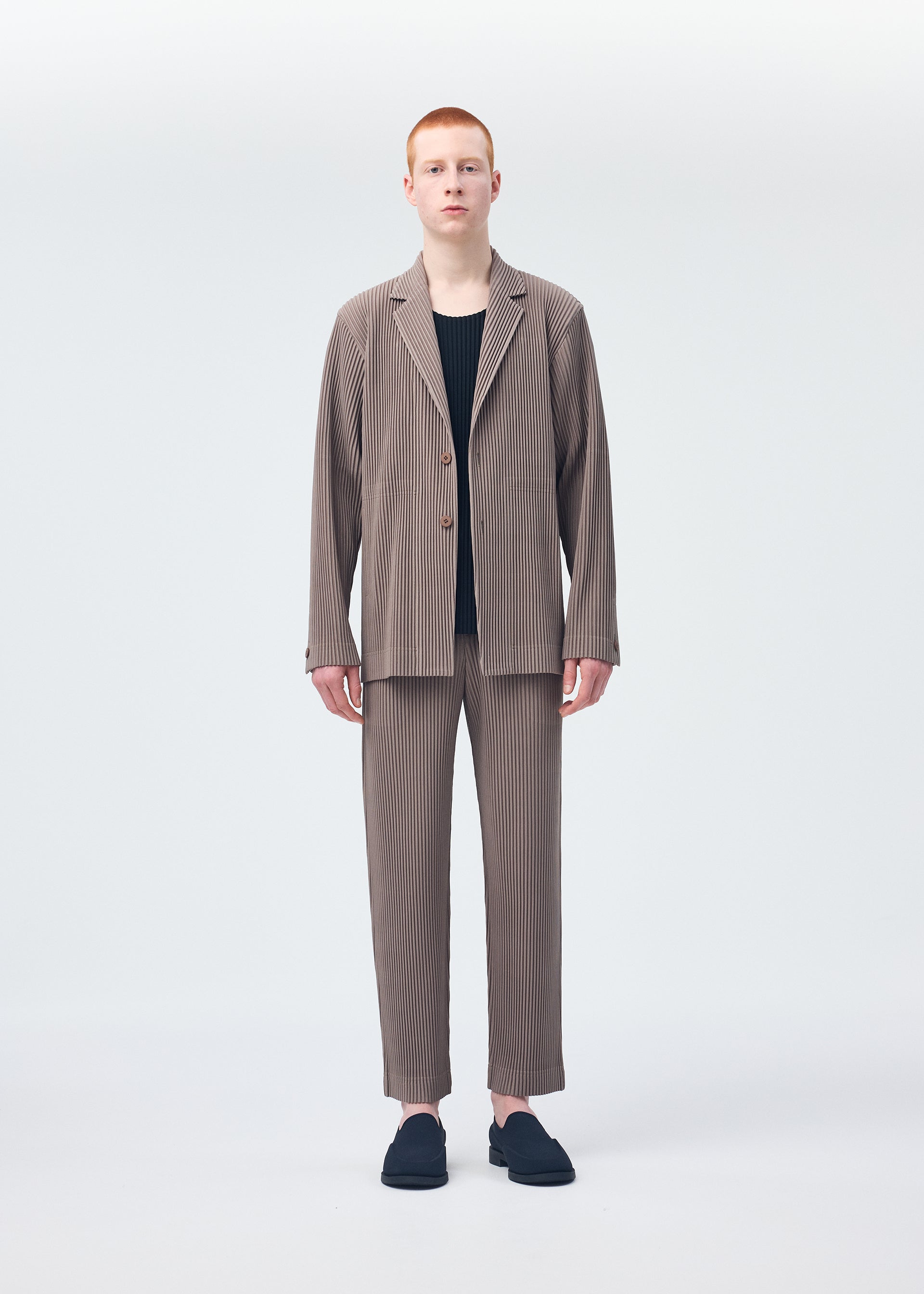 A model wears the HOMME PLISSÉ ISSEY MIYAKE TAILORED PLEATS 1 jacket.