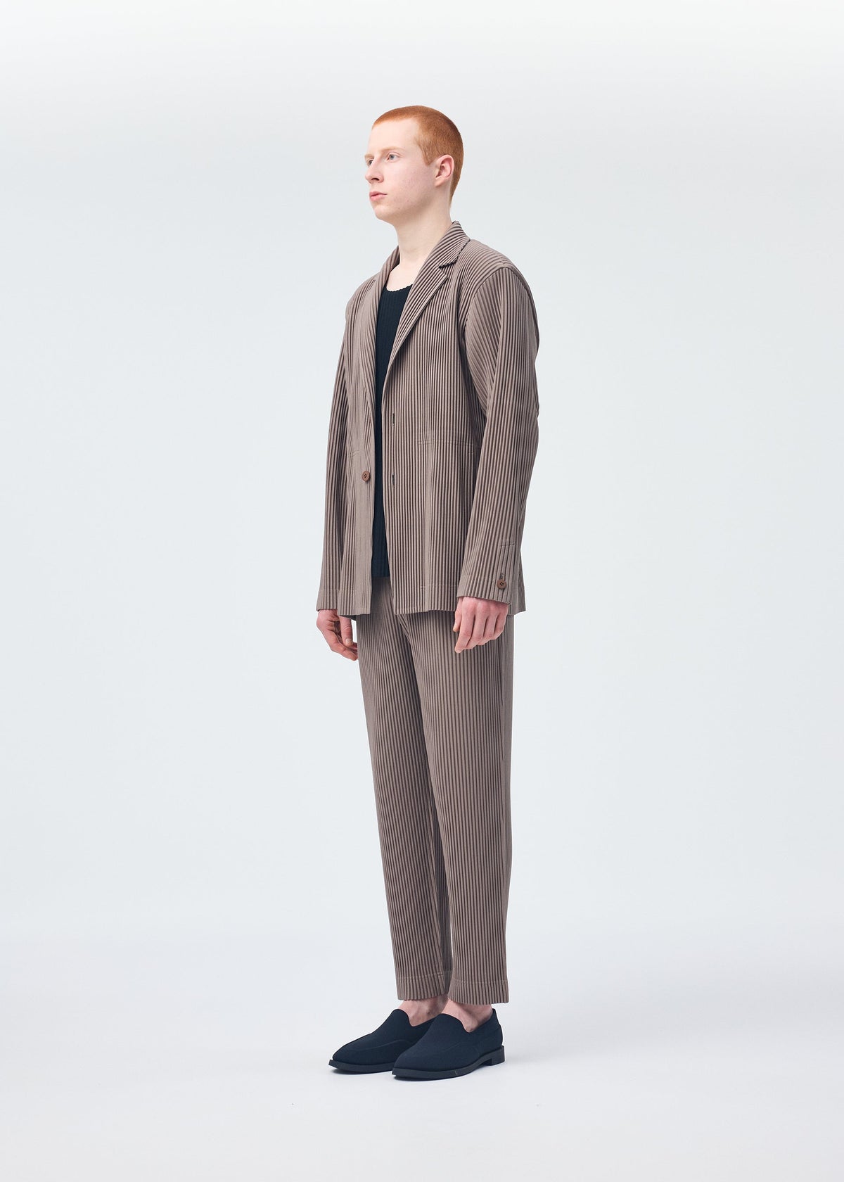 A model wears the HOMME PLISSÉ ISSEY MIYAKE TAILORED PLEATS 1 jacket.