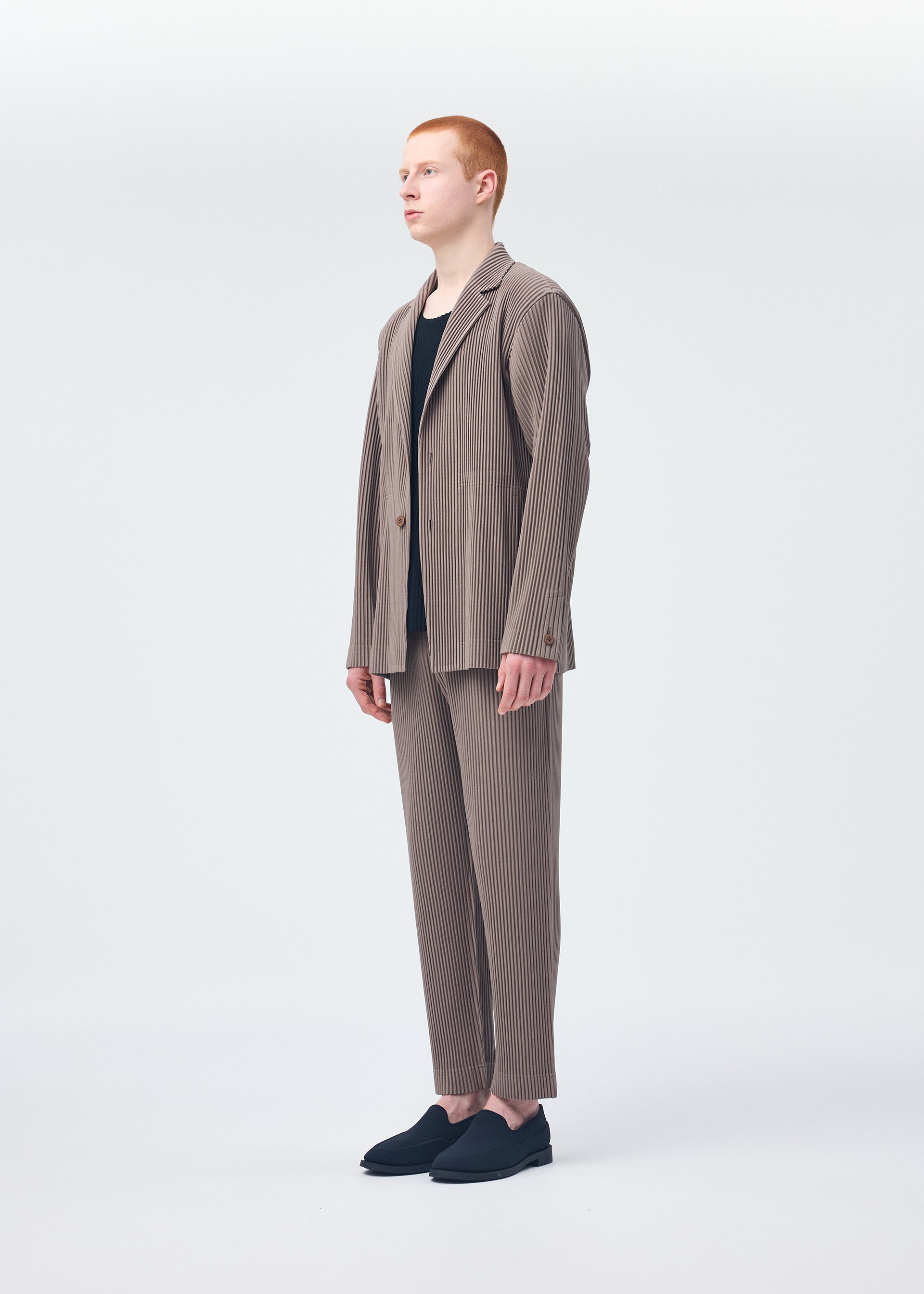 A model wears the HOMME PLISSÉ ISSEY MIYAKE TAILORED PLEATS 1 jacket.