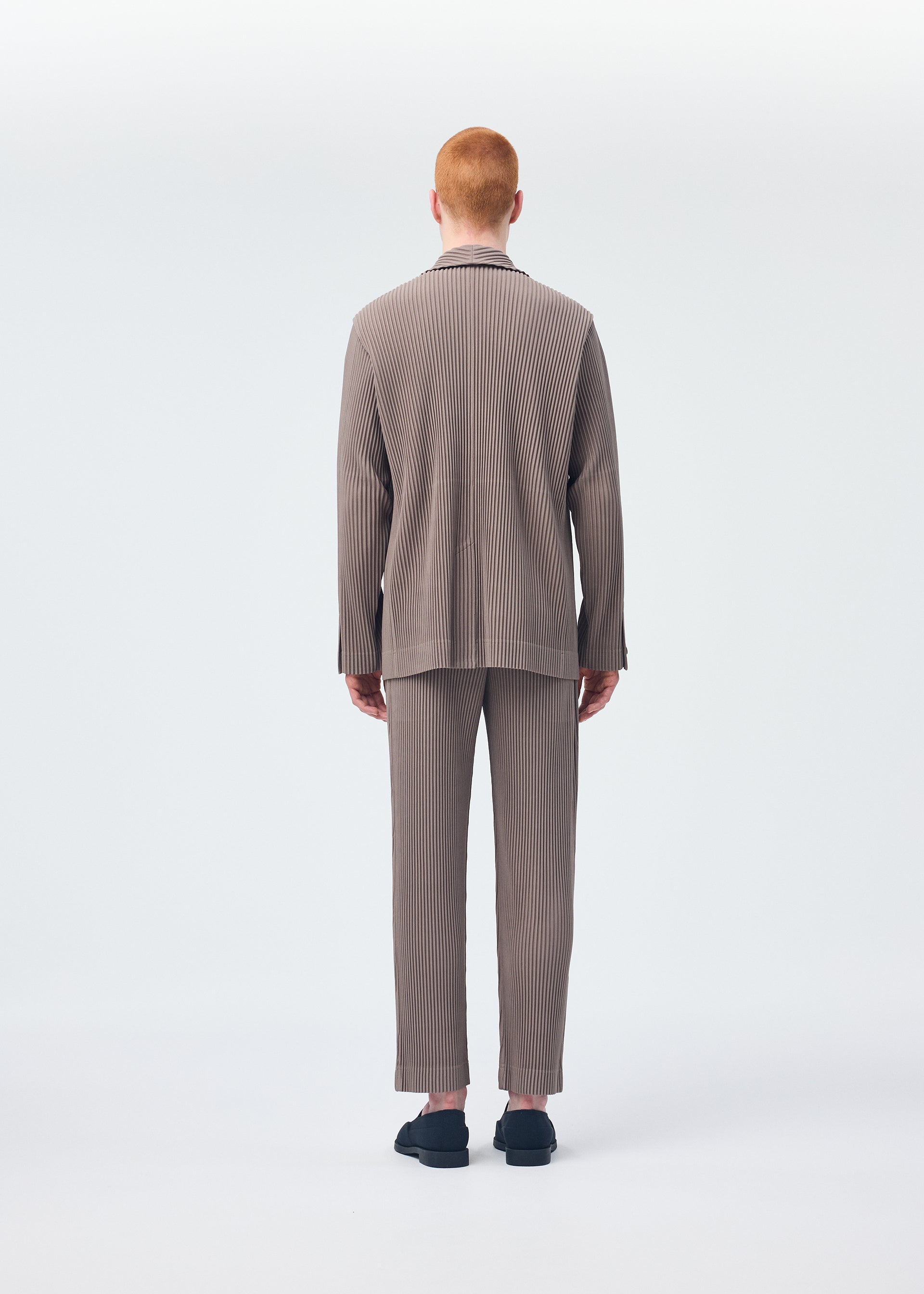 A model wears the HOMME PLISSÉ ISSEY MIYAKE TAILORED PLEATS 1 jacket.