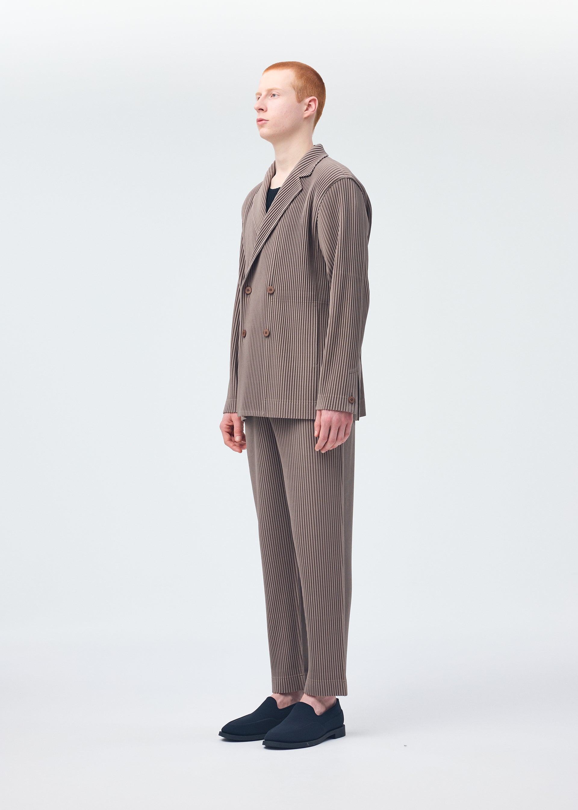 A model wears the HOMME PLISSÉ ISSEY MIYAKE TAILORED PLEATS 1 jacket.