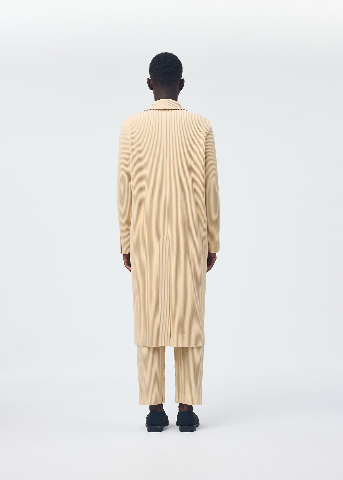 A model wears the HOMME PLISSÉ ISSEY MIYAKE TAILORED PLEATS 2 clothing.