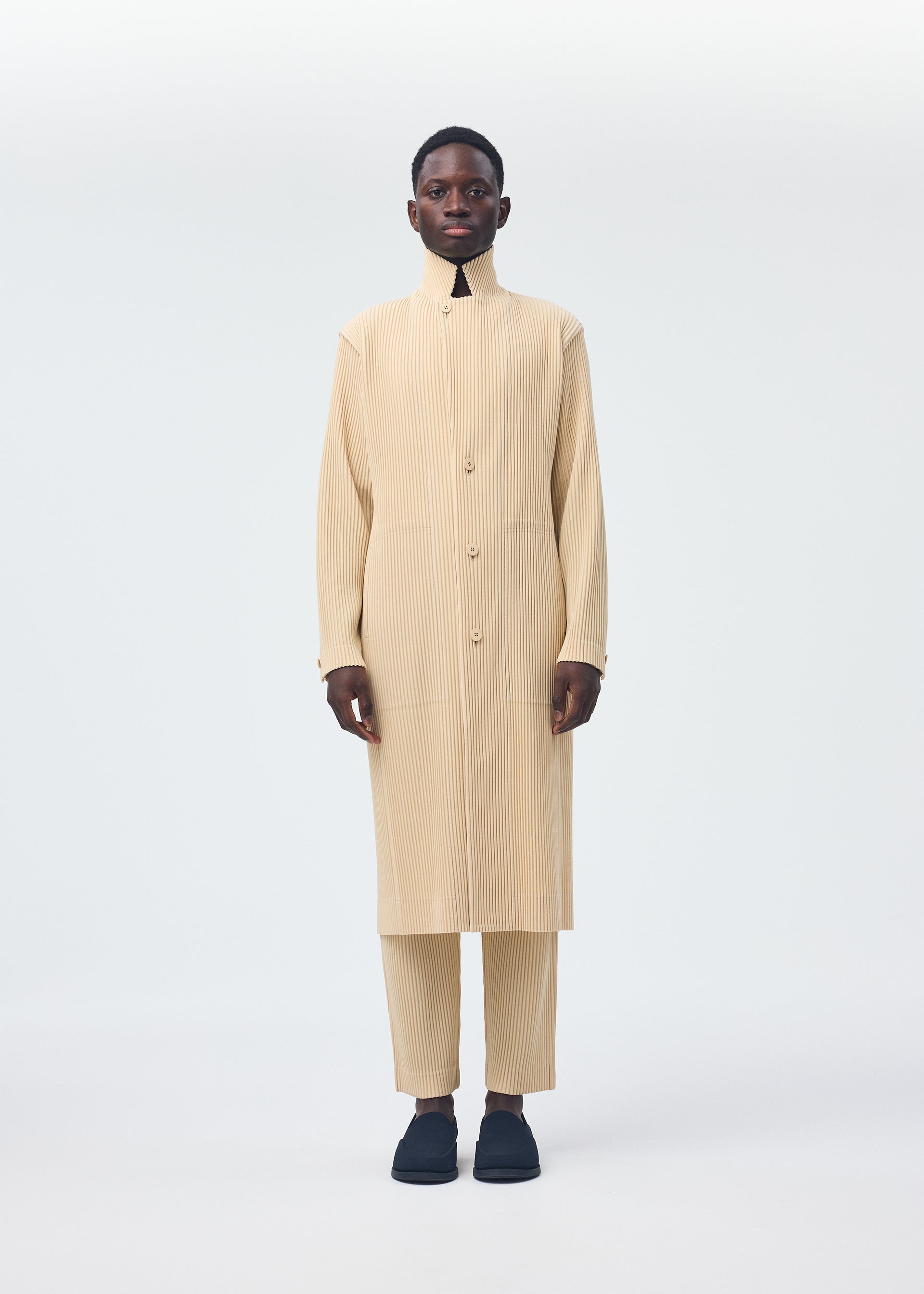A model wears the HOMME PLISSÉ ISSEY MIYAKE TAILORED PLEATS 2 clothing.
