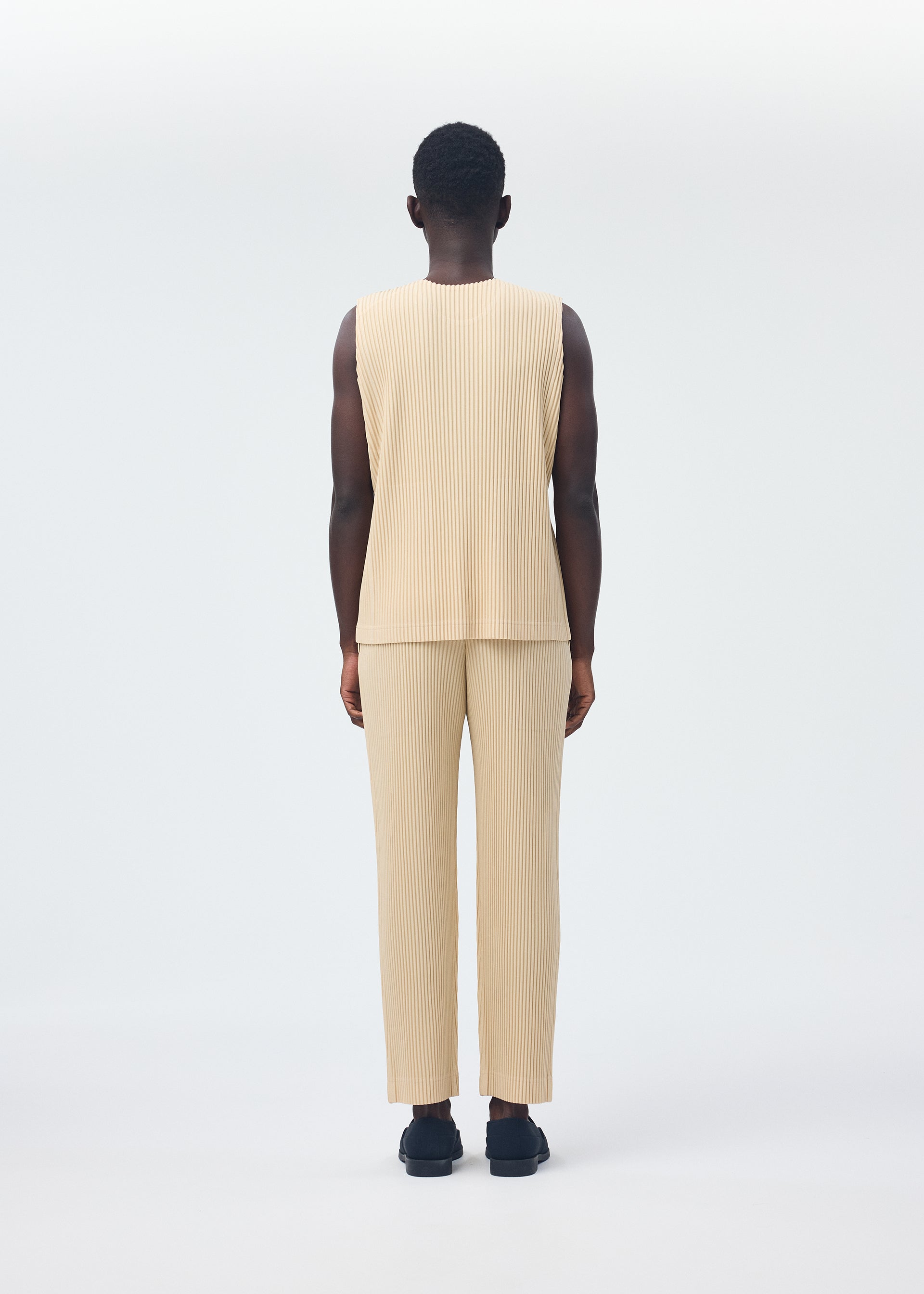 A model wears the HOMME PLISSÉ ISSEY MIYAKE TAILORED PLEATS 2 clothing.