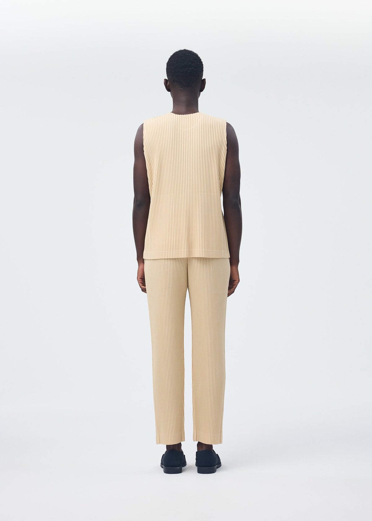 A model wears the HOMME PLISSÉ ISSEY MIYAKE TAILORED PLEATS 2 clothing.
