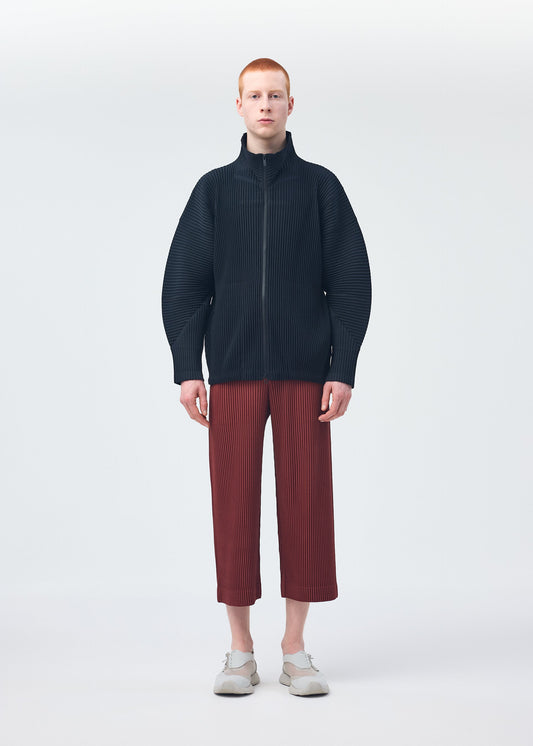 A model wears the HOMME PLISSÉ ISSEY MIYAKE MONTHLY COLORS AUGUST trousers.