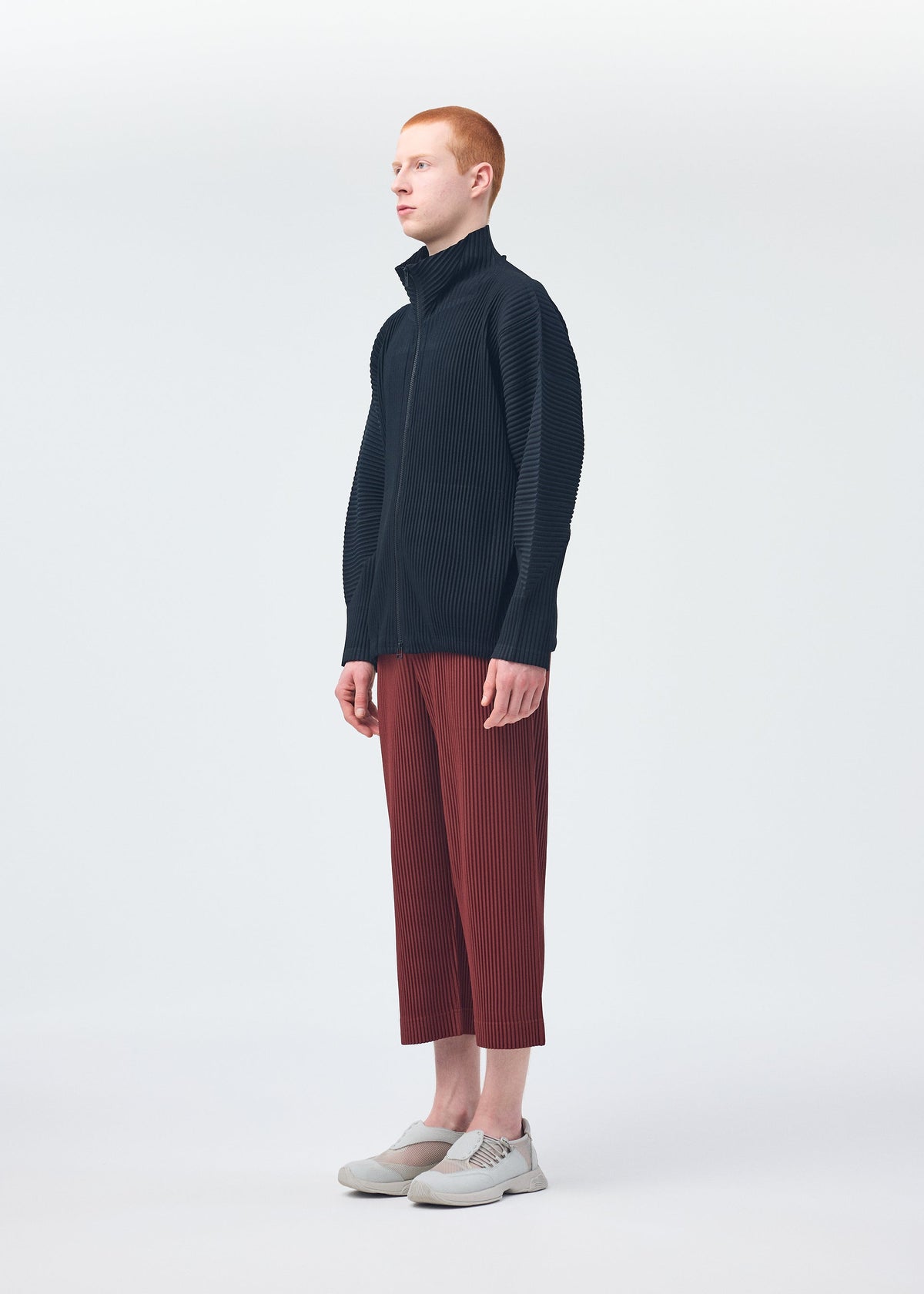 A model wears the HOMME PLISSÉ ISSEY MIYAKE MONTHLY COLORS AUGUST trousers.