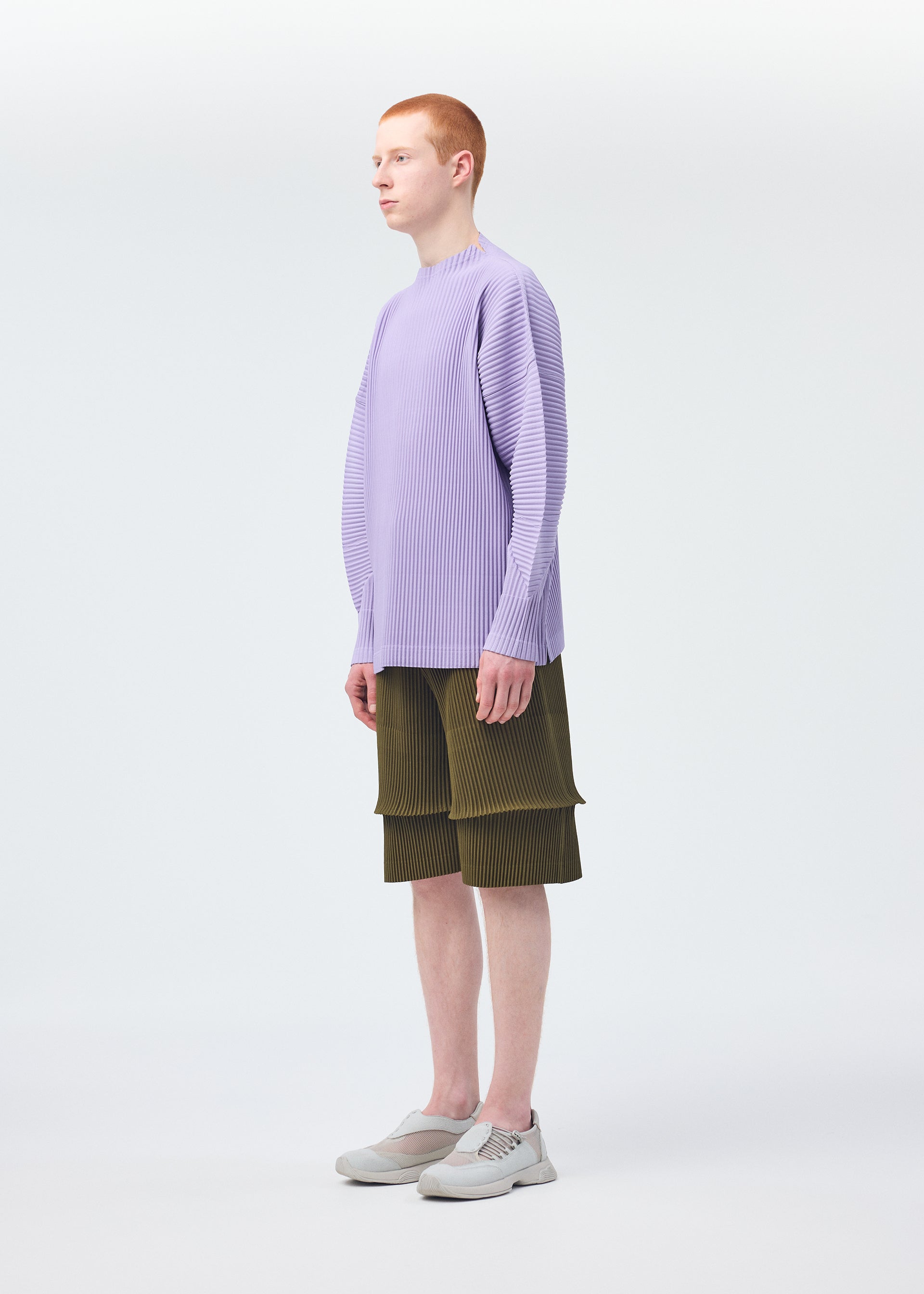 A model wears the HOMME PLISSÉ ISSEY MIYAKE PLEATS BOTTOMS 2 clothing.