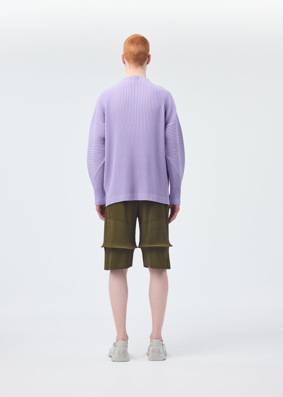A model wears the HOMME PLISSÉ ISSEY MIYAKE PLEATS BOTTOMS 2 clothing.