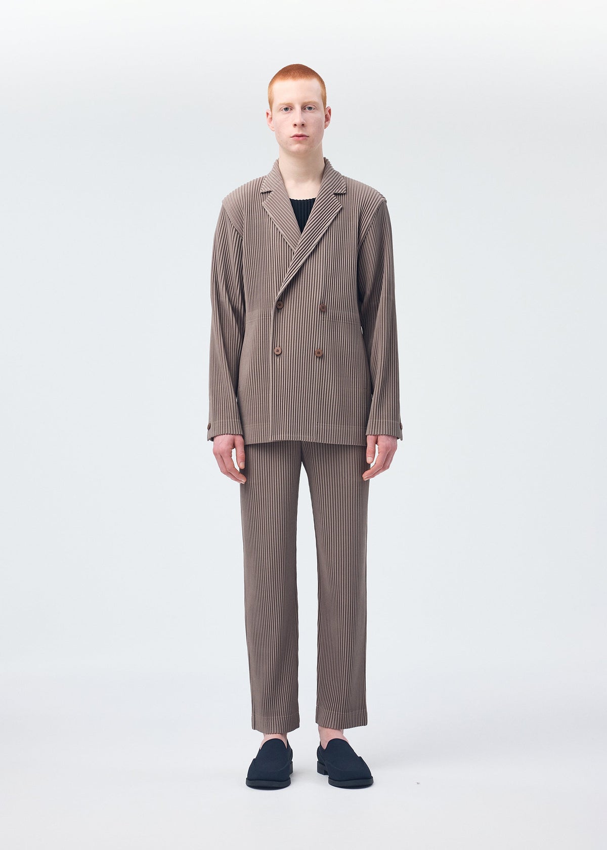 A model wears the HOMME PLISSÉ ISSEY MIYAKE TAILORED PLEATS 1 trousers.