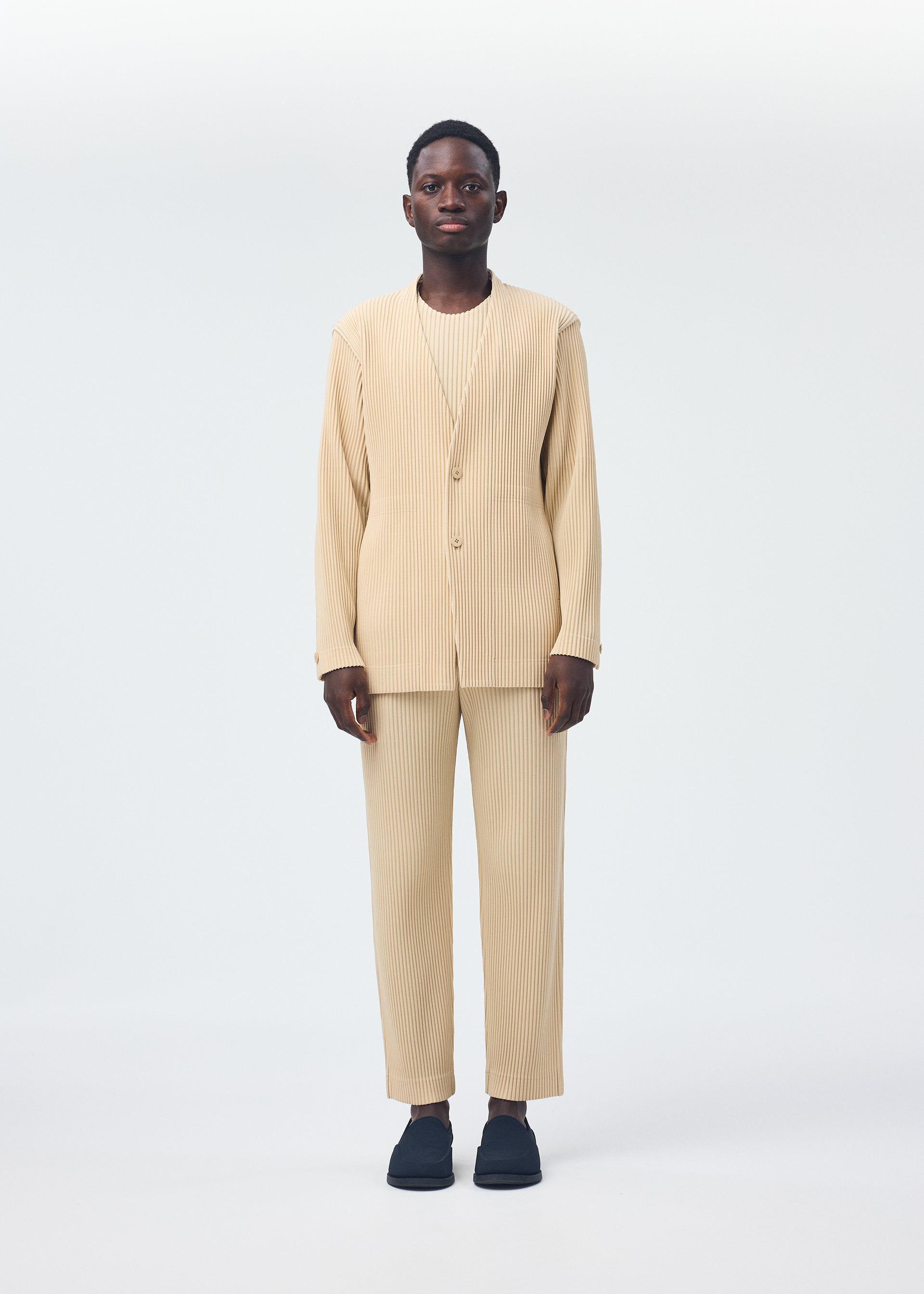 A model wears the HOMME PLISSÉ ISSEY MIYAKE TAILORED PLEATS 2 clothing.
