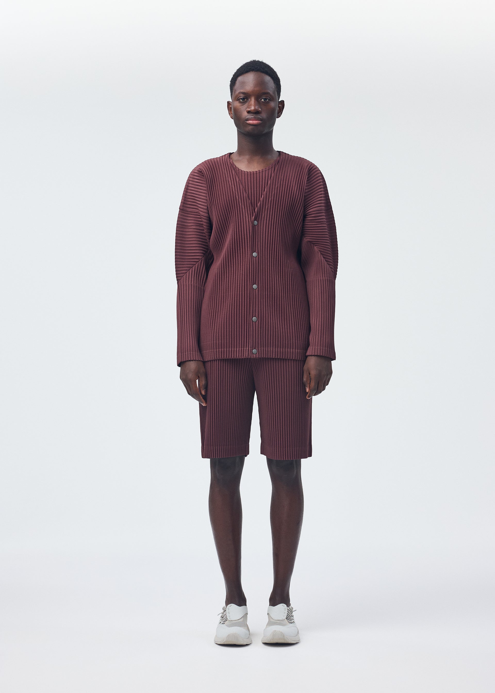 A model wears the HOMME PLISSÉ ISSEY MIYAKE COLOR PLEATS trousers.