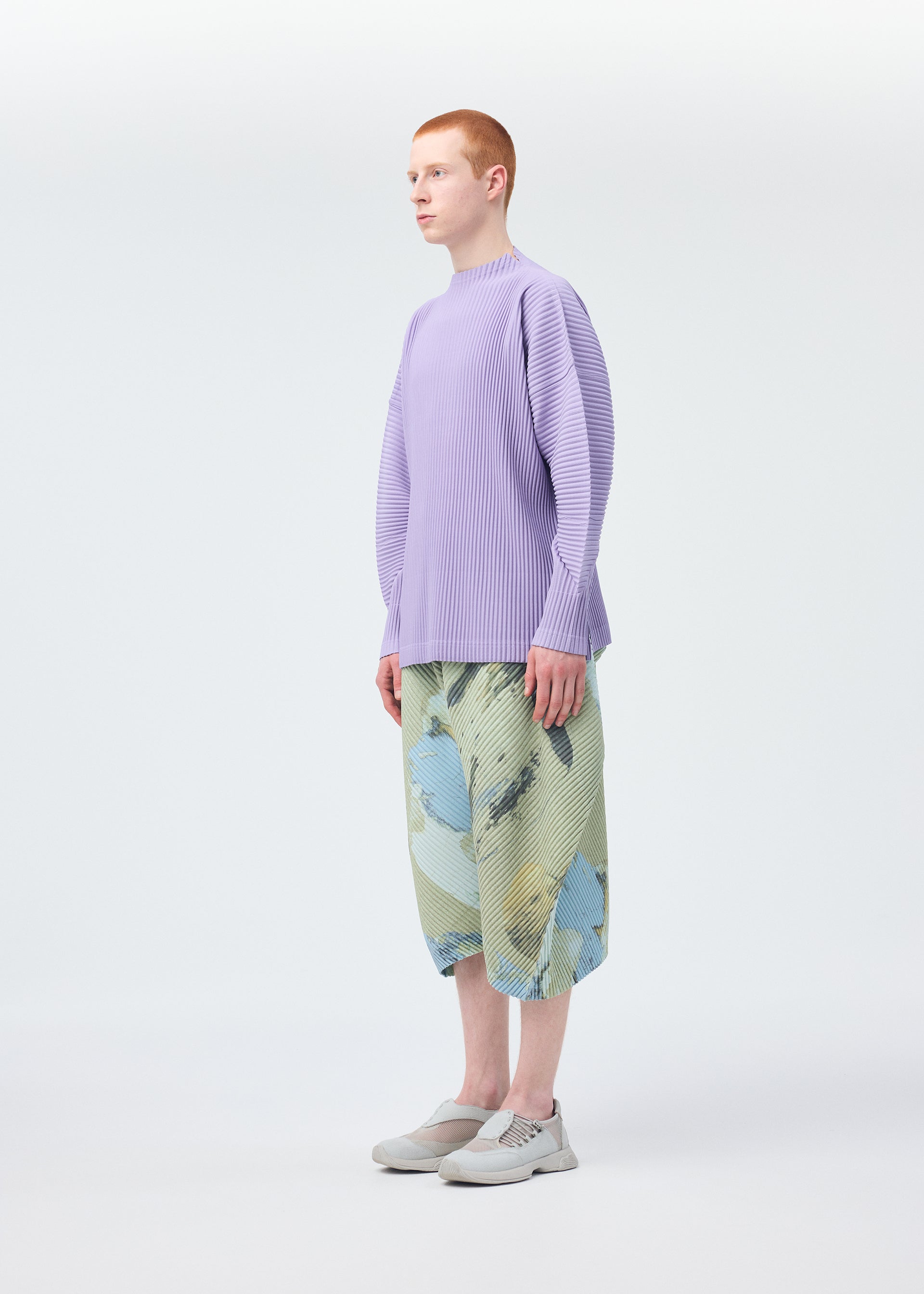 A model wears the HOMME PLISSÉ ISSEY MIYAKE PAINTED STONE clothing.