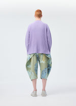 A model wears the HOMME PLISSÉ ISSEY MIYAKE PAINTED STONE clothing.