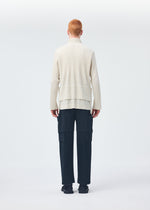 A model wears the HOMME PLISSÉ ISSEY MIYAKE MULTI POCKET trousers.