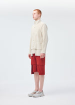 A model wears the HOMME PLISSÉ ISSEY MIYAKE MULTI POCKET trousers.