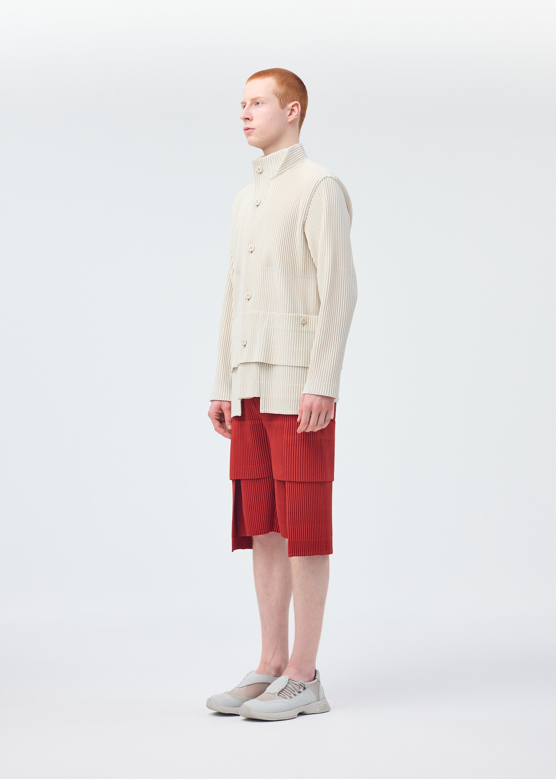 A model wears the HOMME PLISSÉ ISSEY MIYAKE MULTI POCKET trousers.
