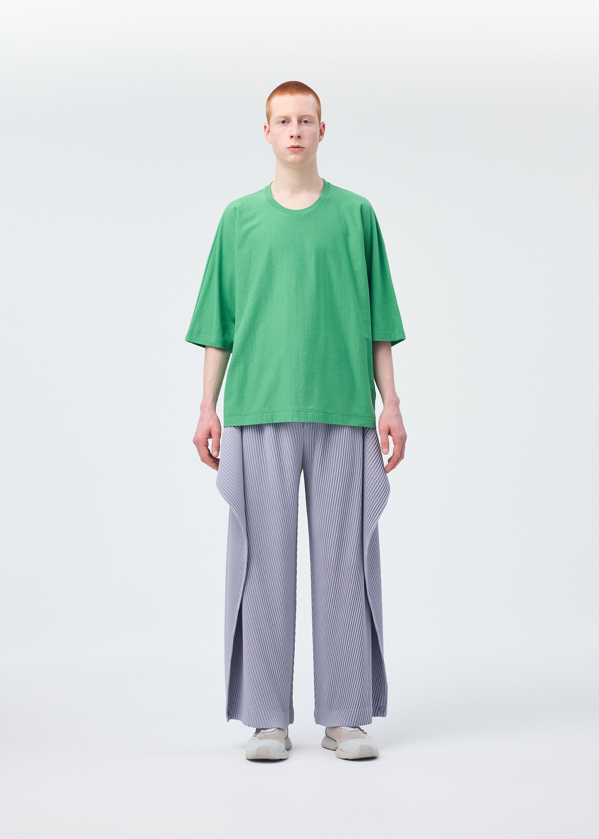 A model wears the HOMME PLISSÉ ISSEY MIYAKE ANGULAR STONE trousers.