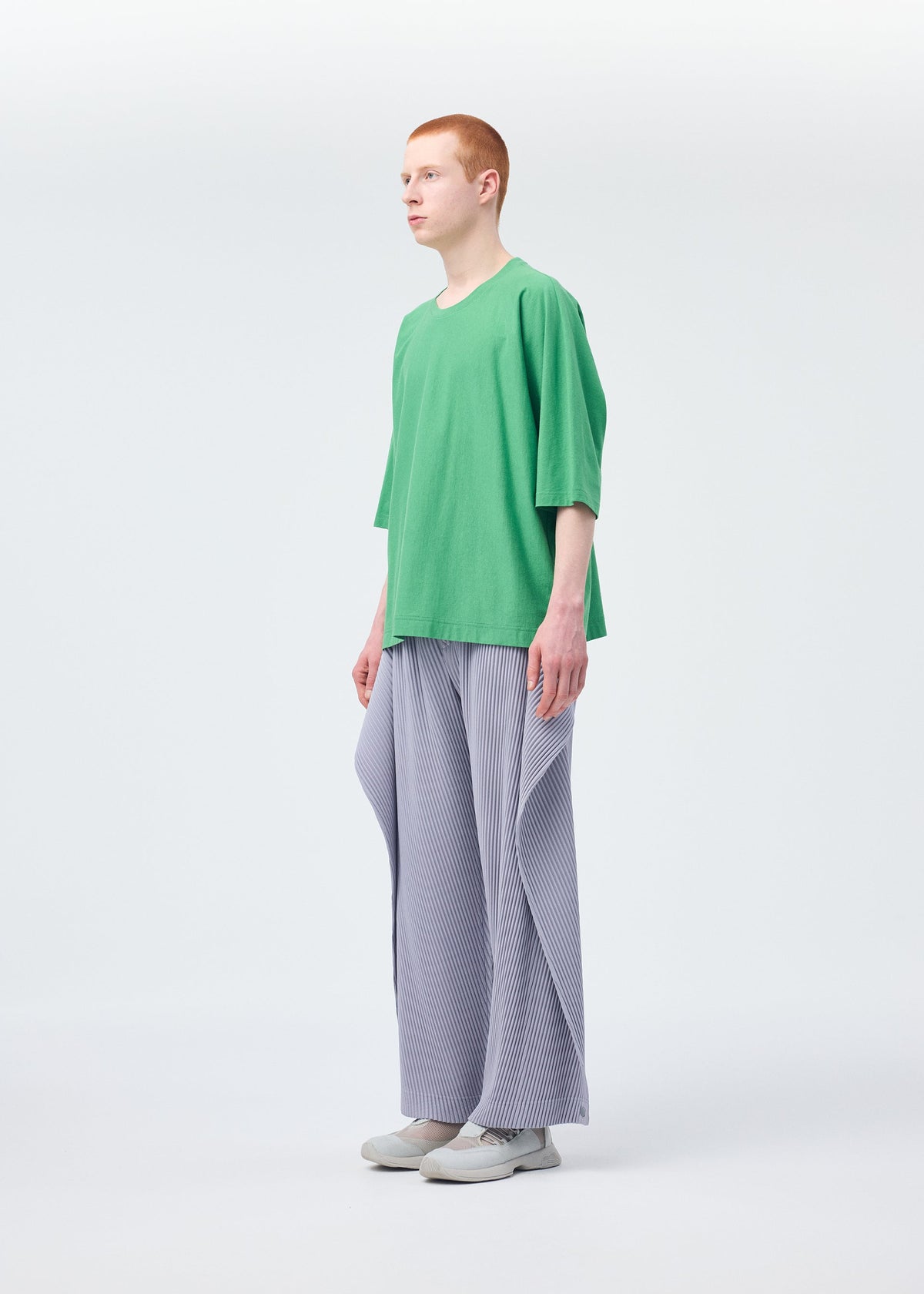 A model wears the HOMME PLISSÉ ISSEY MIYAKE ANGULAR STONE trousers.