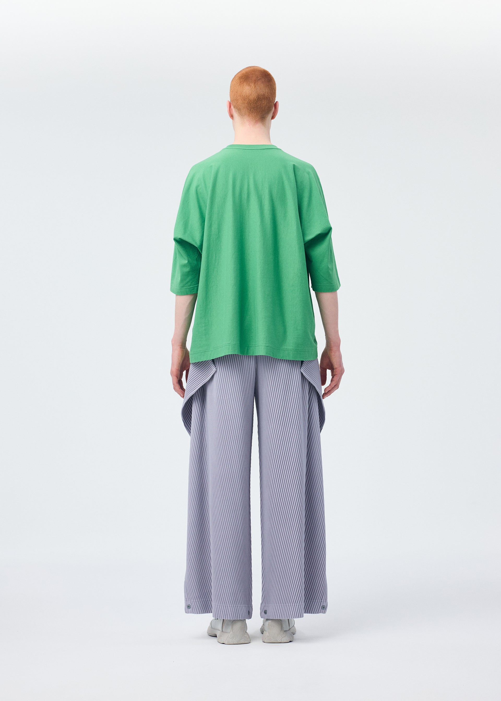 A model wears the HOMME PLISSÉ ISSEY MIYAKE ANGULAR STONE trousers.