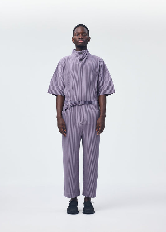 A model wears the HOMME PLISSÉ ISSEY MIYAKE PLEATS BOTTOMS 1 jumpsuit.
