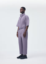 A model wears the HOMME PLISSÉ ISSEY MIYAKE PLEATS BOTTOMS 1 jumpsuit.