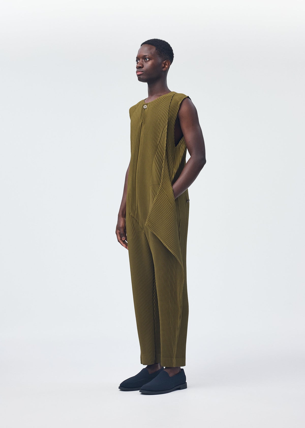 A model wears the HOMME PLISSÉ ISSEY MIYAKE PLEATS BOTTOMS 2 clothing.