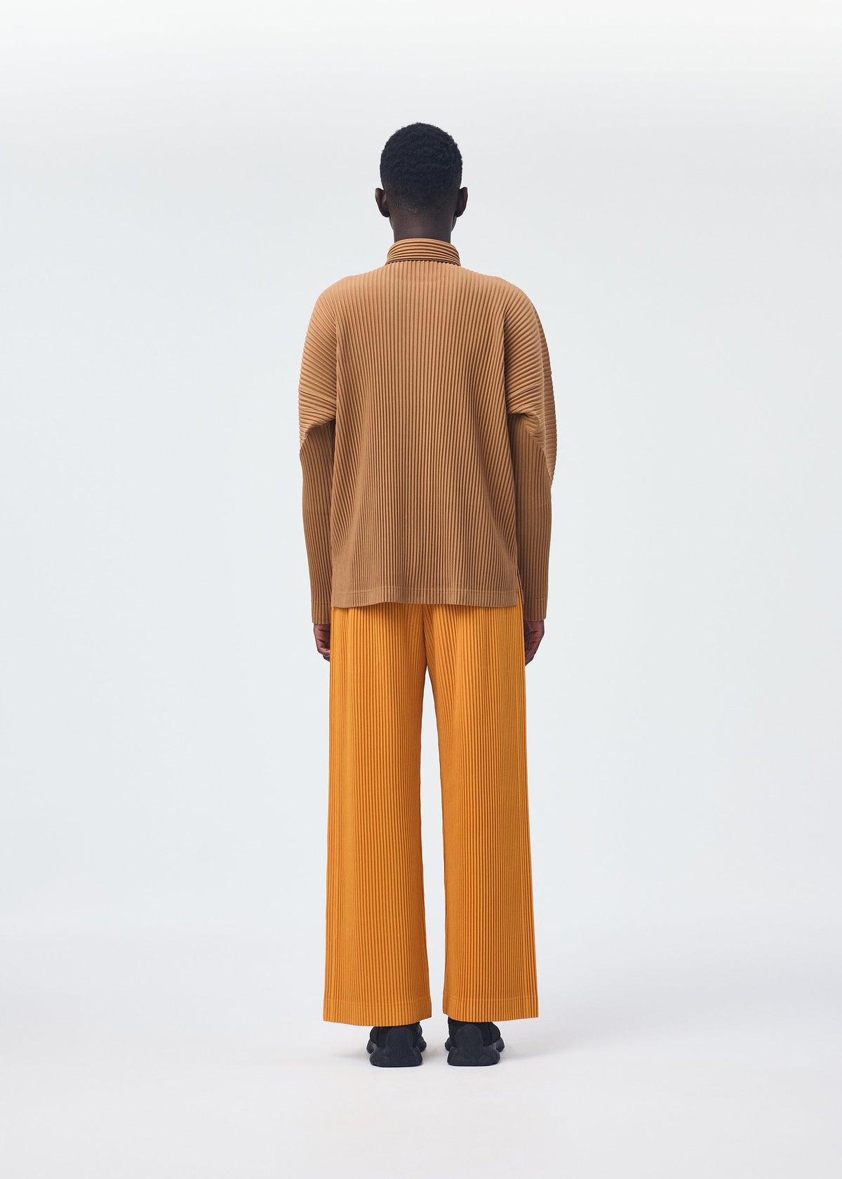 A model wears the HOMME PLISSÉ ISSEY MIYAKE MONTHLY COLORS OCTOBER shirt.
