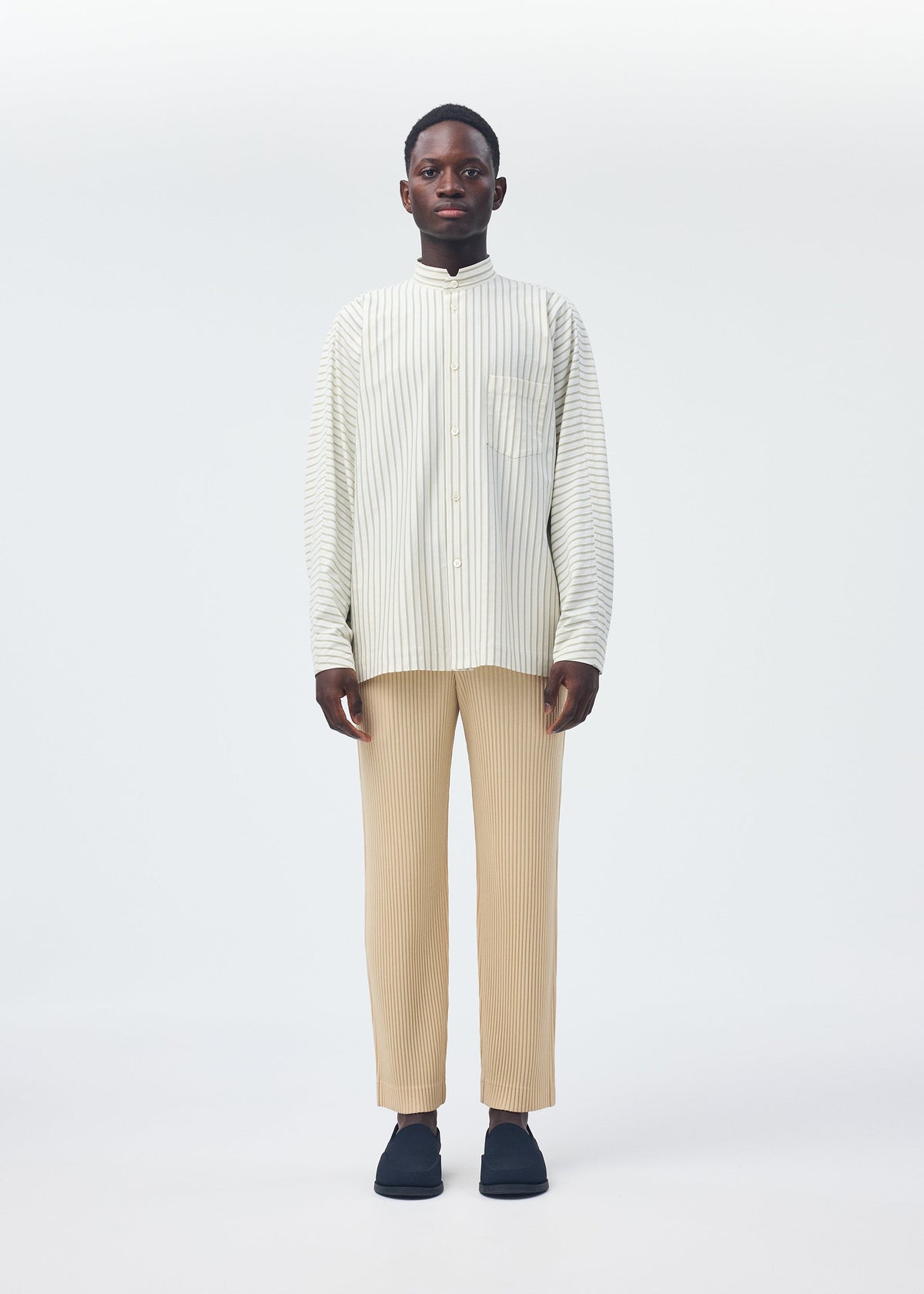 A model wears the HOMME PLISSÉ ISSEY MIYAKE STRIPE JERSEY SHIRT clothing.