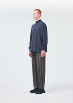 A model wears the HOMME PLISSÉ ISSEY MIYAKE Black Turtleneck Top top.