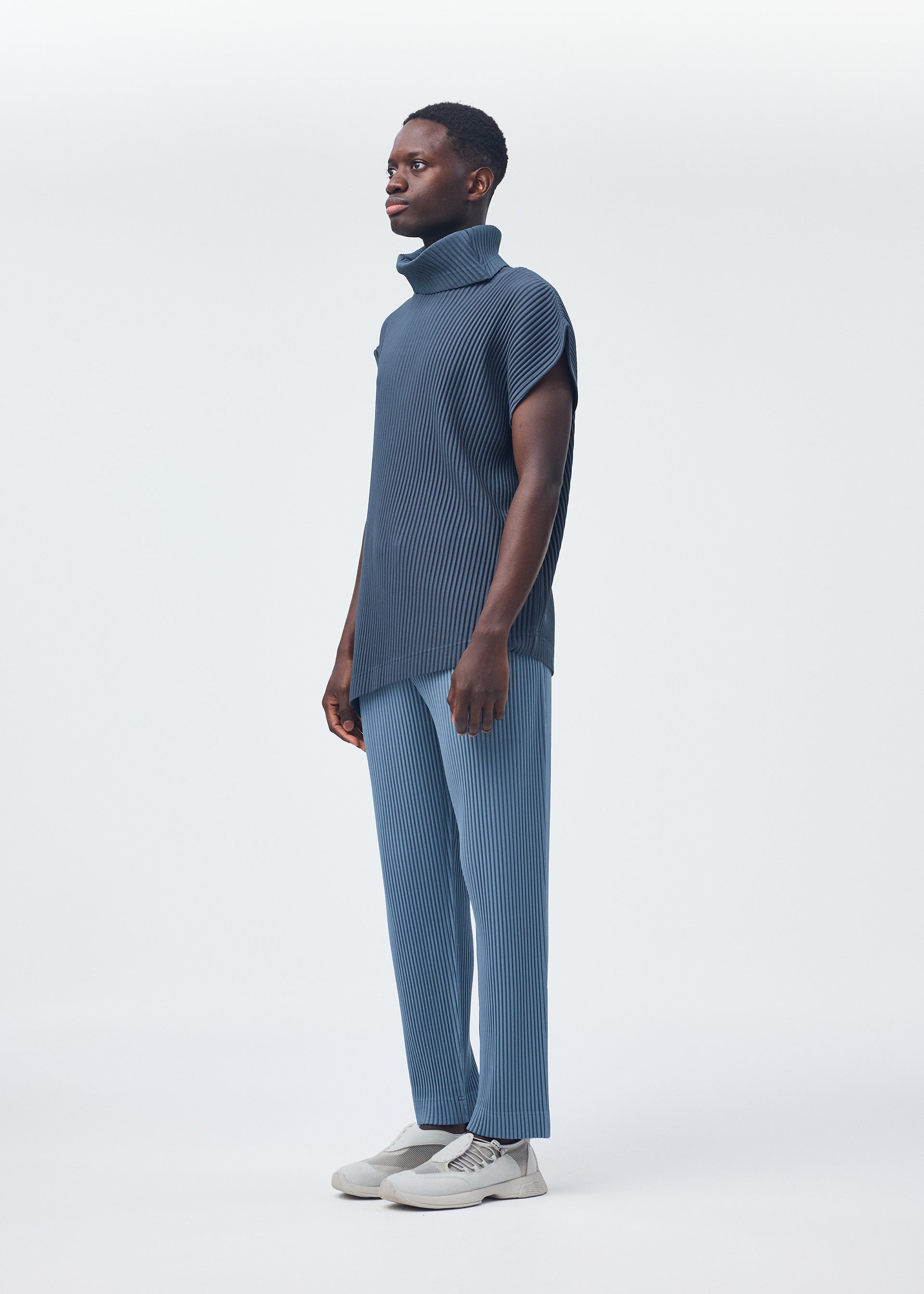 A model wears the HOMME PLISSÉ ISSEY MIYAKE ANGULAR STONE top.