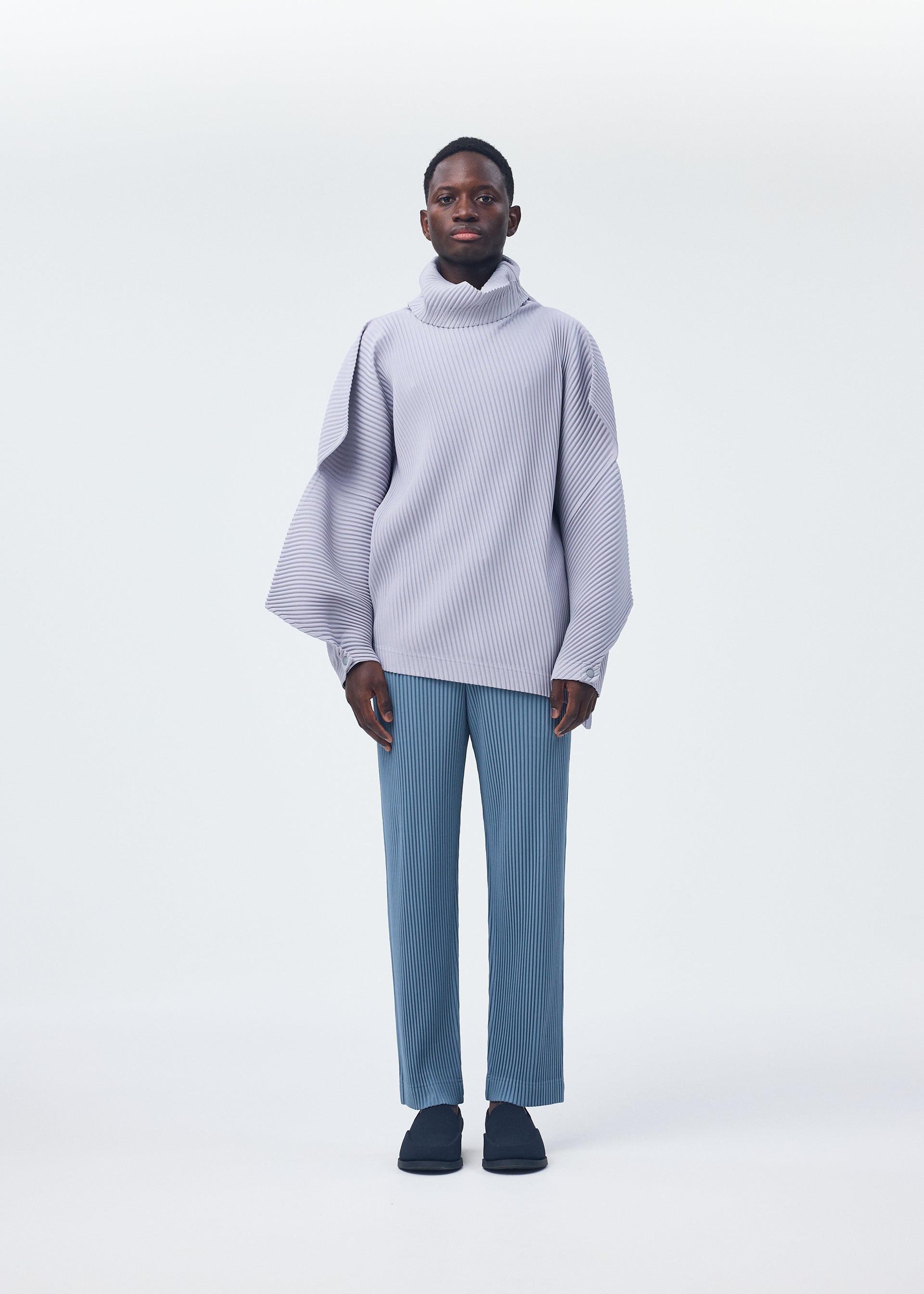 A model wears the HOMME PLISSÉ ISSEY MIYAKE ANGULAR STONE top.