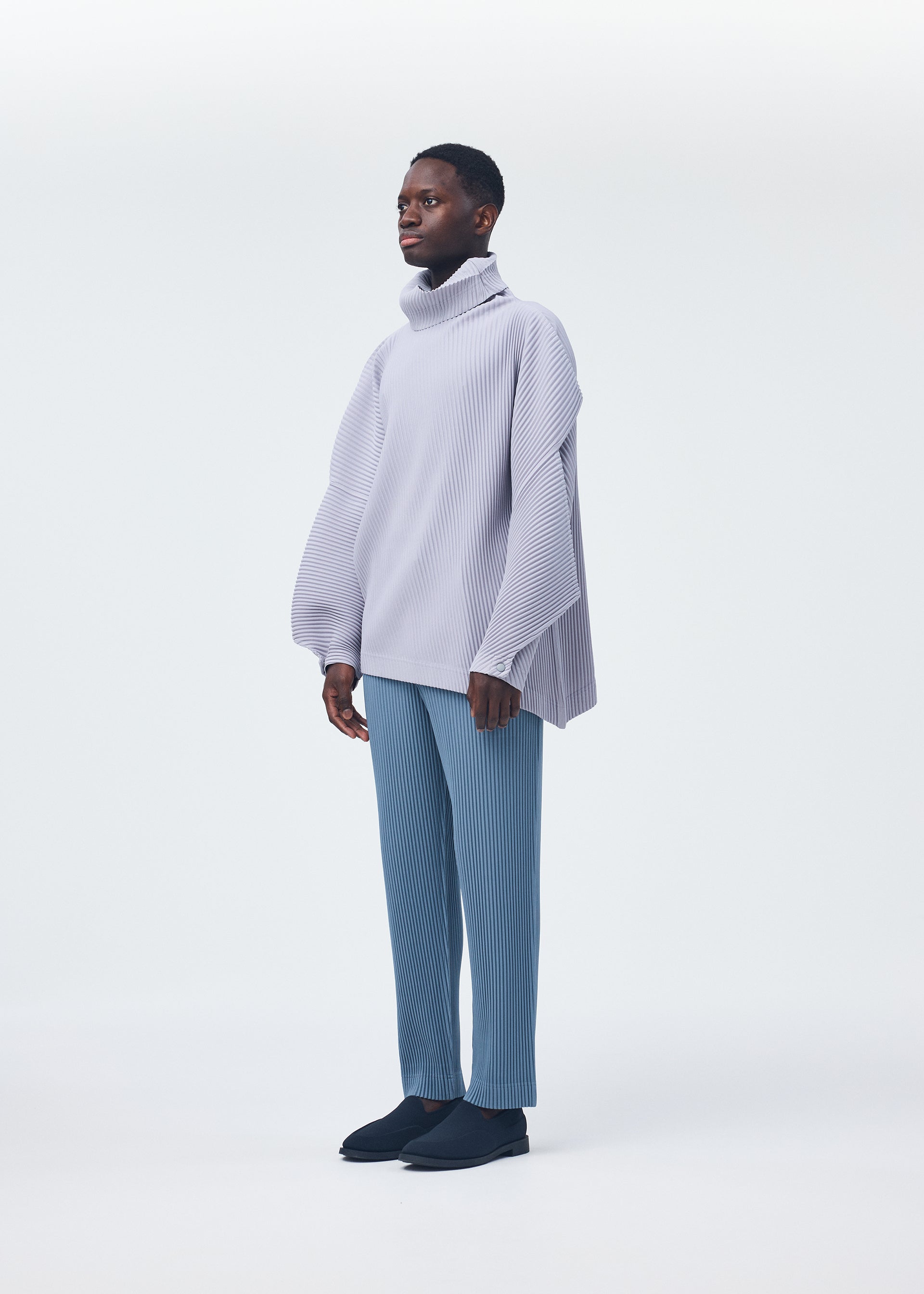 A model wears the HOMME PLISSÉ ISSEY MIYAKE ANGULAR STONE top.