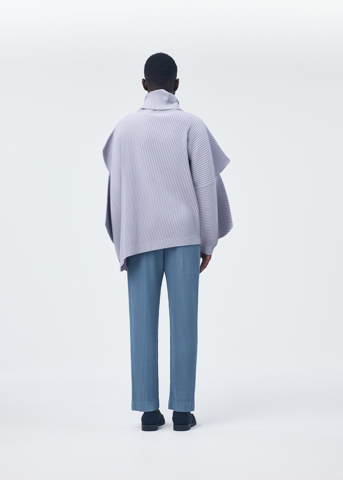 A model wears the HOMME PLISSÉ ISSEY MIYAKE ANGULAR STONE top.