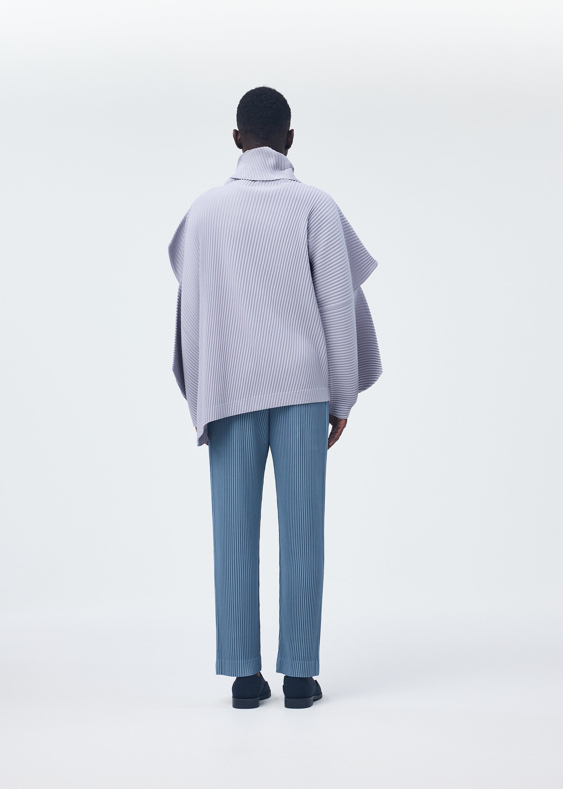 A model wears the HOMME PLISSÉ ISSEY MIYAKE ANGULAR STONE top.