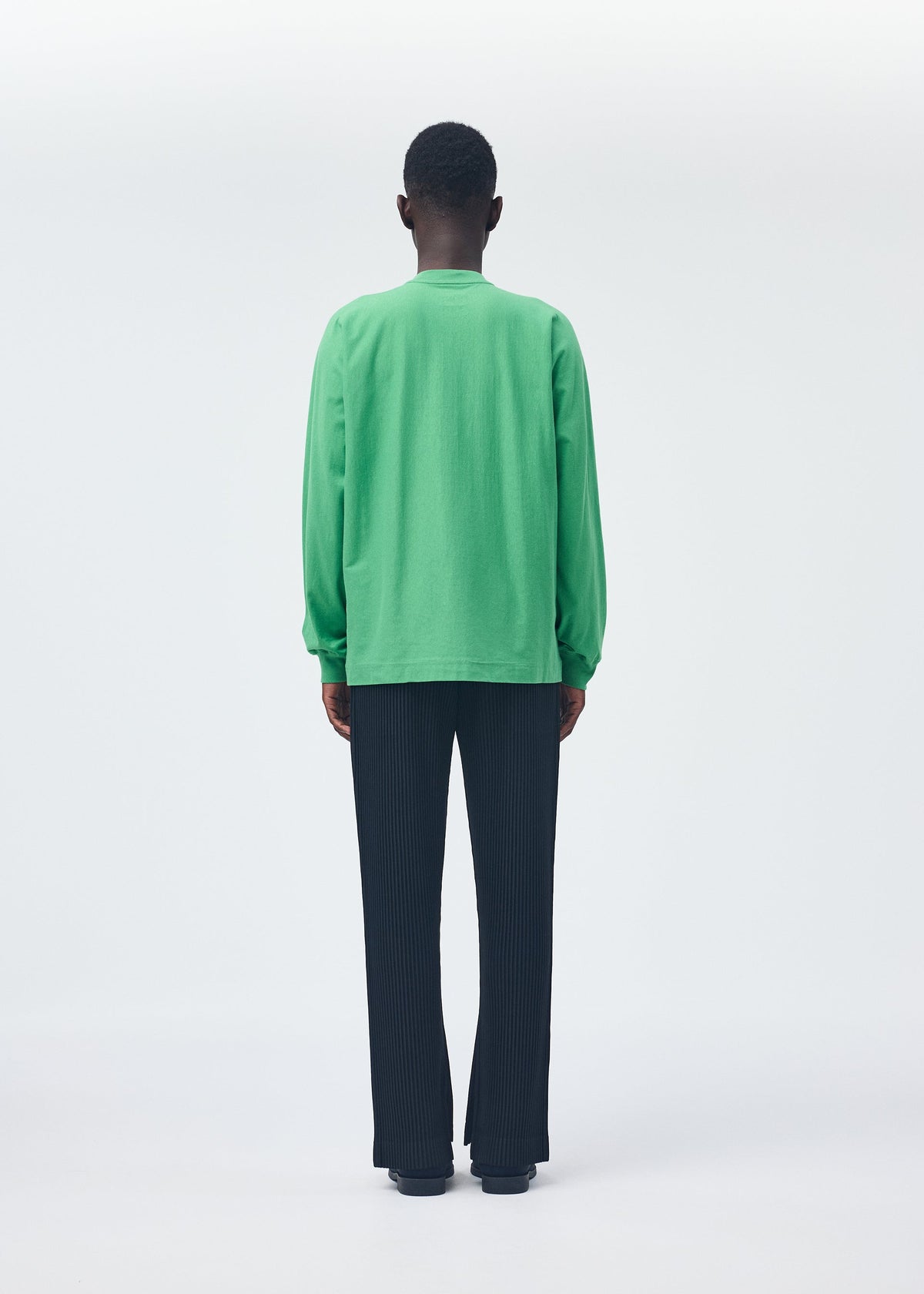 A model wears the HOMME PLISSÉ ISSEY MIYAKE RELEASE T 1 top.