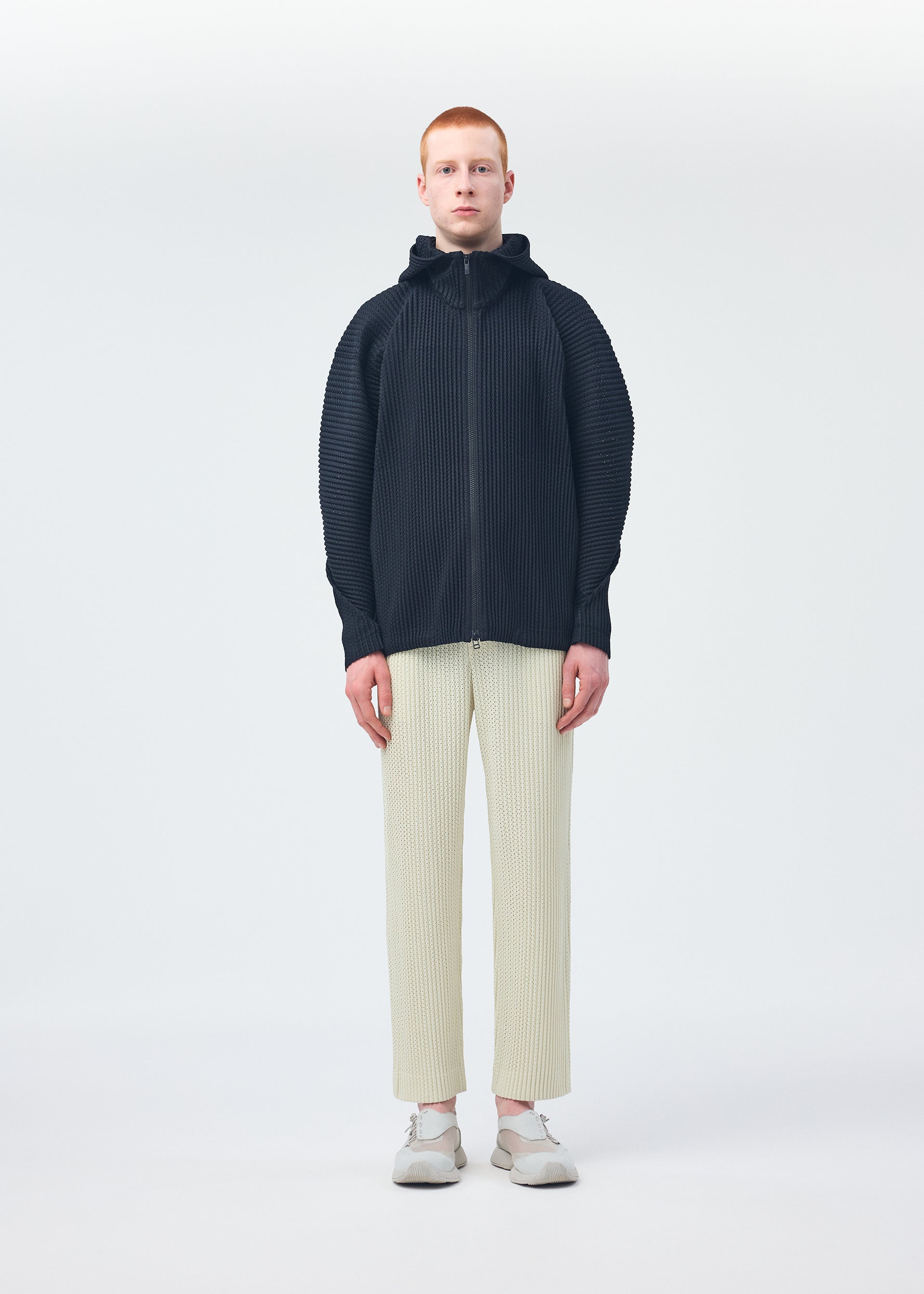A model wears the HOMME PLISSÉ ISSEY MIYAKE WICKERWORK MESH shirt.