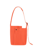 A product shot of the HOMME PLISSÉ ISSEY MIYAKE UTILITY bag in portofino buoy orange (33).