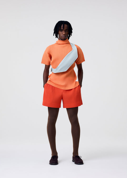 A model wears the HOMME PLISSÉ ISSEY MIYAKE VERSATILE CROSSBODY bag.