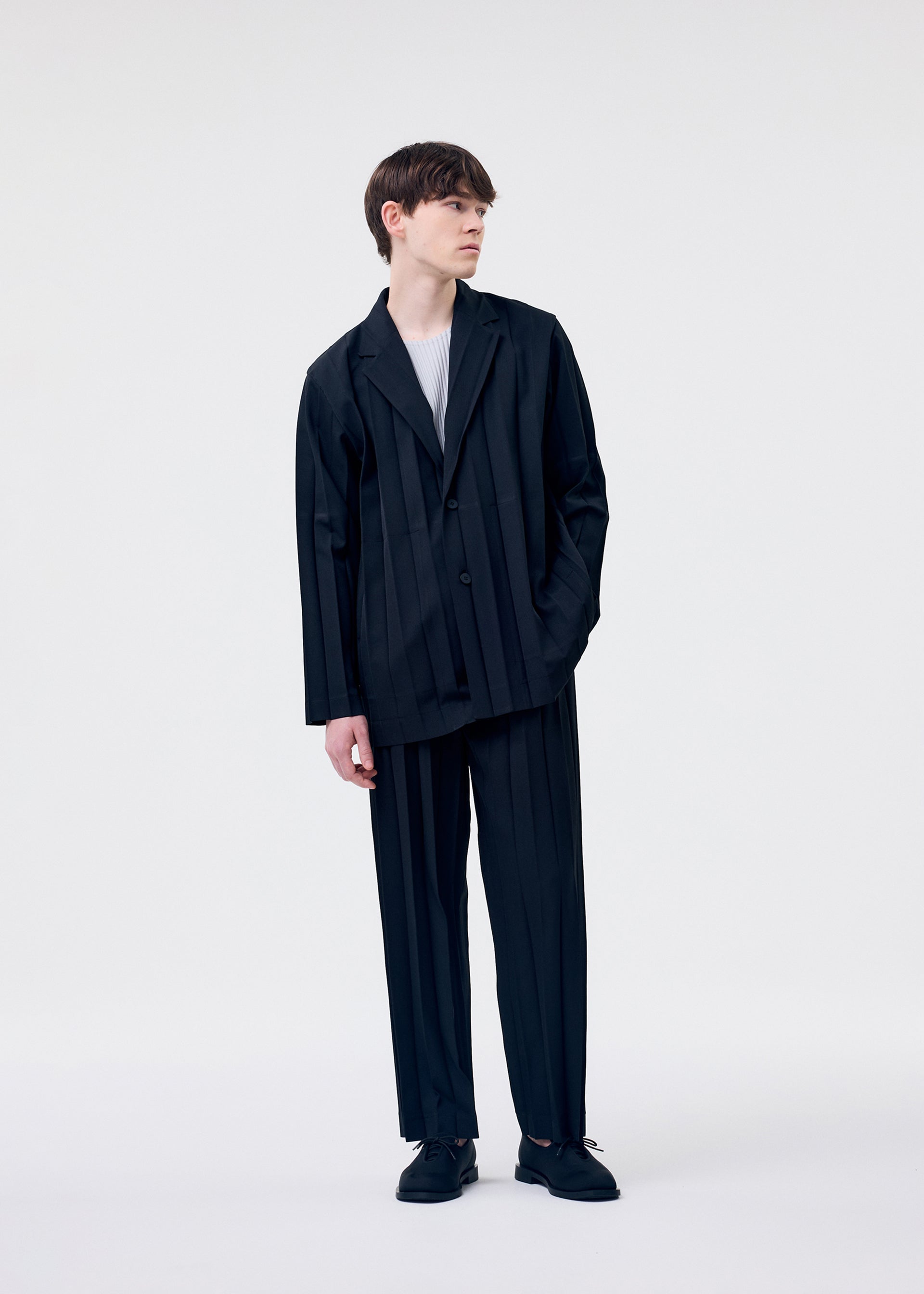A model wears the HOMME PLISSÉ ISSEY MIYAKE EDGE ENSEMBLE jacket.