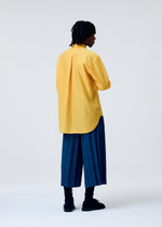 A model wears the HOMME PLISSÉ ISSEY MIYAKE EDGE ENSEMBLE trousers.