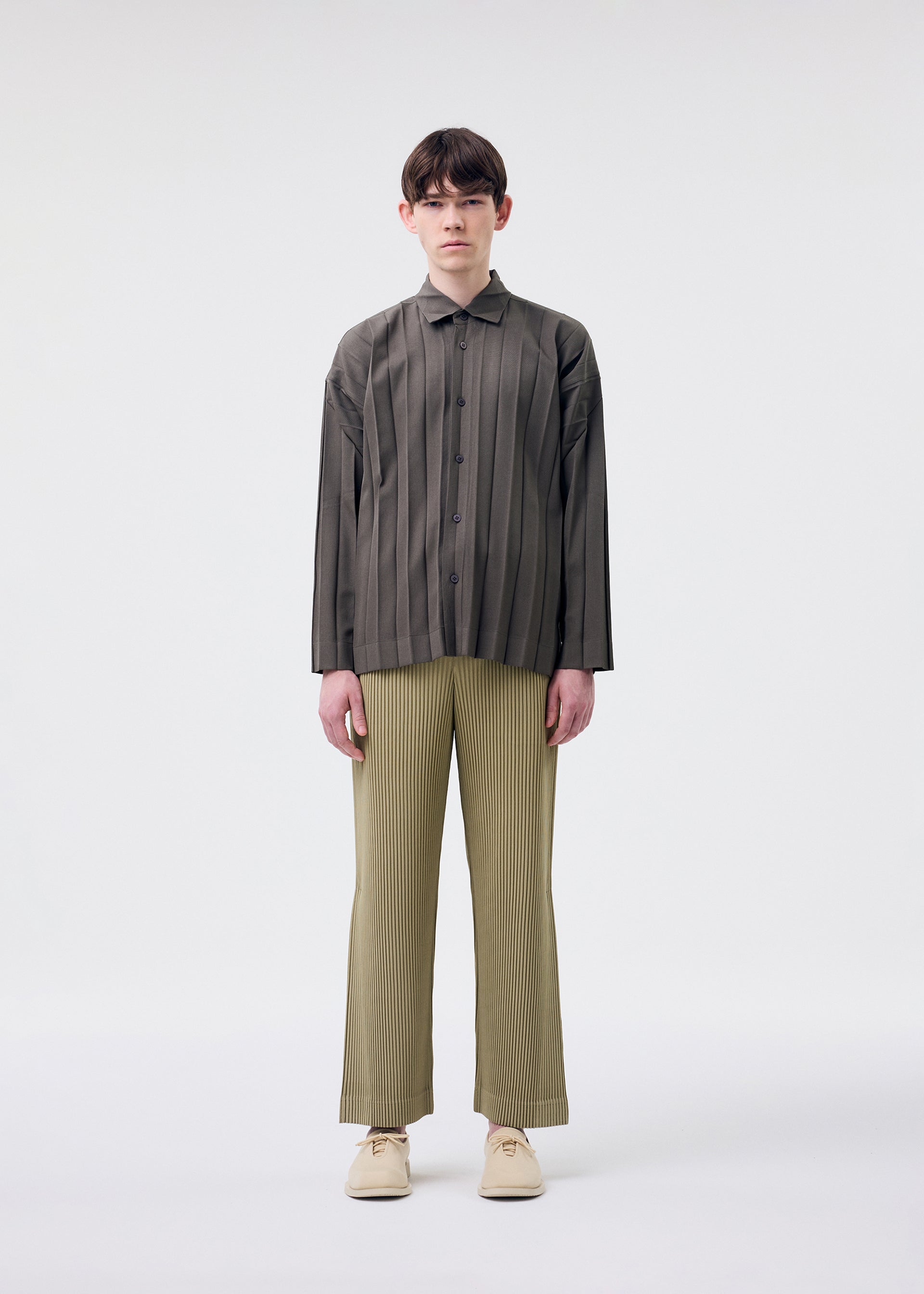 A model wears the HOMME PLISSÉ ISSEY MIYAKE EDGE ENSEMBLE shirt.
