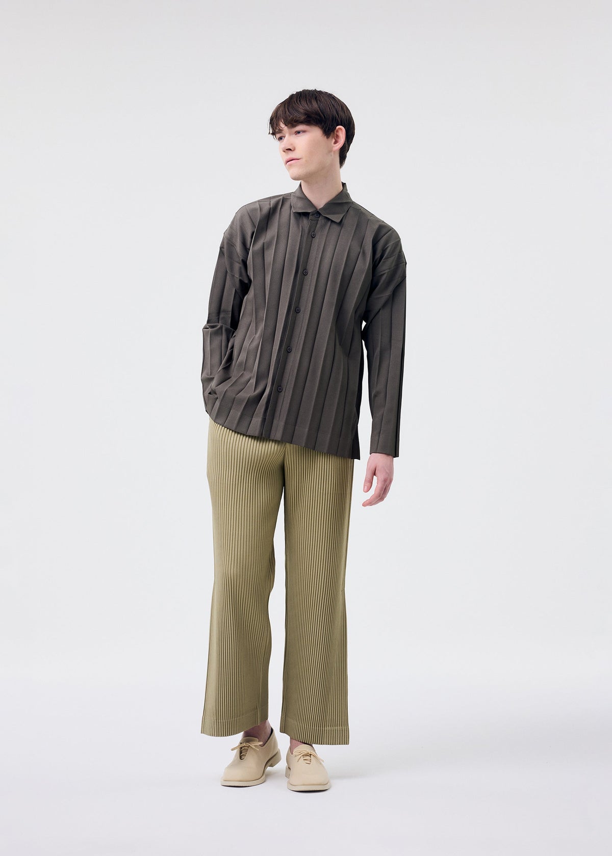 A model wears the HOMME PLISSÉ ISSEY MIYAKE EDGE ENSEMBLE shirt.