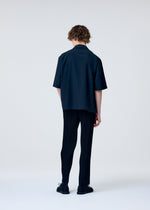 A model wears the HOMME PLISSÉ ISSEY MIYAKE EMBROIDERY PRESS SHIRT shirt.