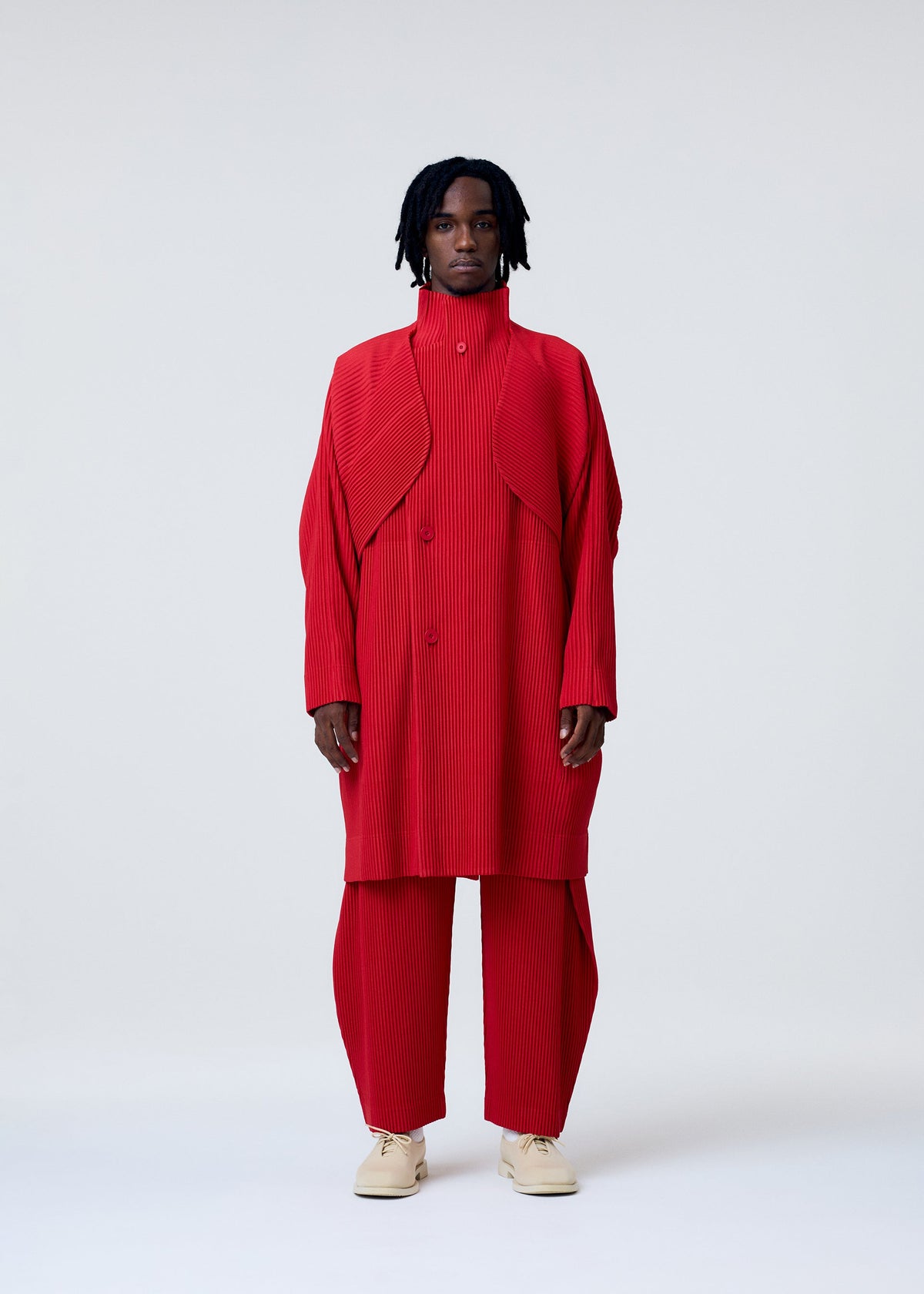 A model wears the HOMME PLISSÉ ISSEY MIYAKE COVER AND FOLD clothing.