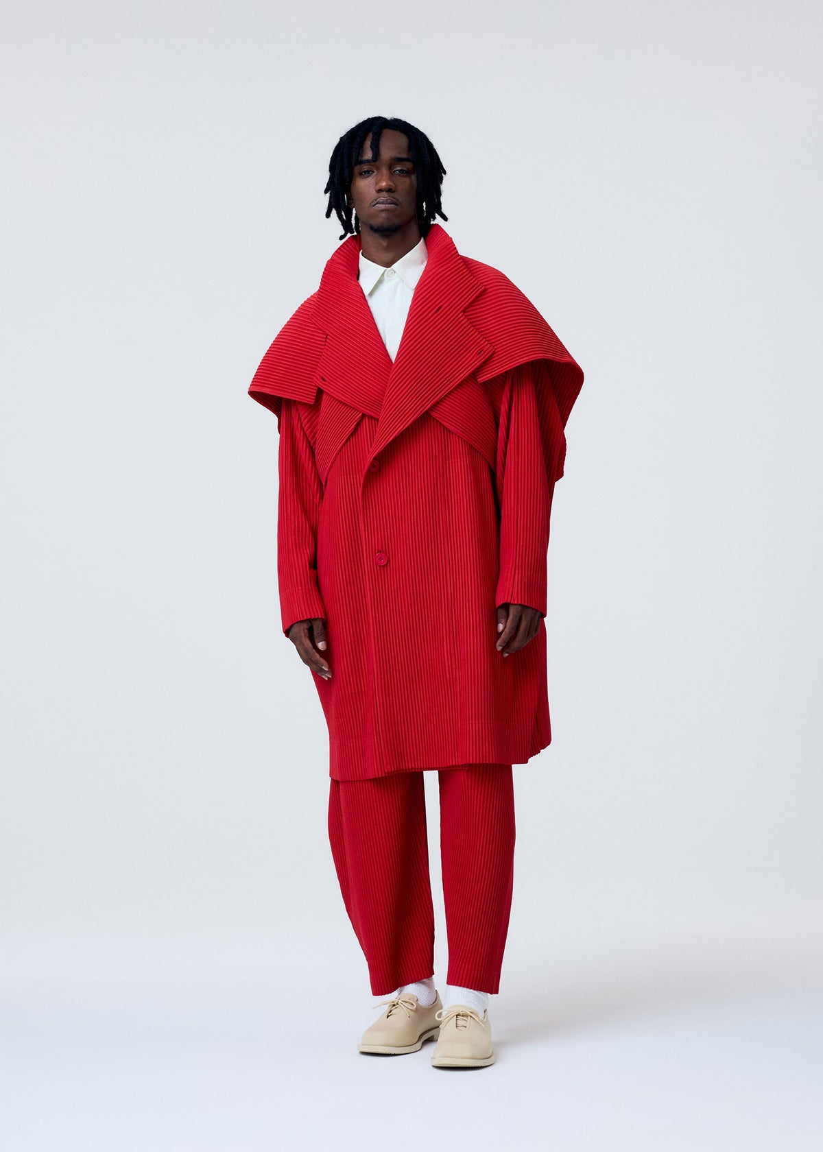 A model wears the HOMME PLISSÉ ISSEY MIYAKE COVER AND FOLD clothing.