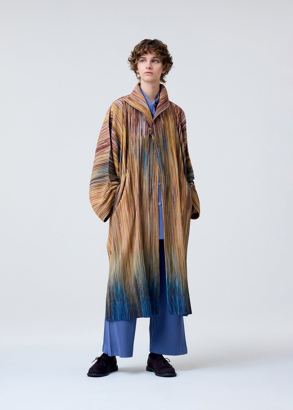 A model wears the HOMME PLISSÉ ISSEY MIYAKE PAINT BRUSH CLOSE UP coat.